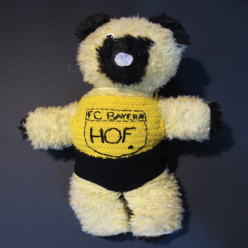 Teddybär mit selbst gehäkeltem FC Bayern Hof Trikot, Leihgabe von Manfred Opitz (die „Herrschaften“)